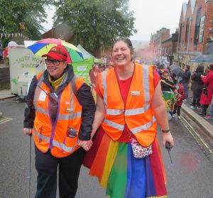 Chair of Pride in Belper walks with crutch